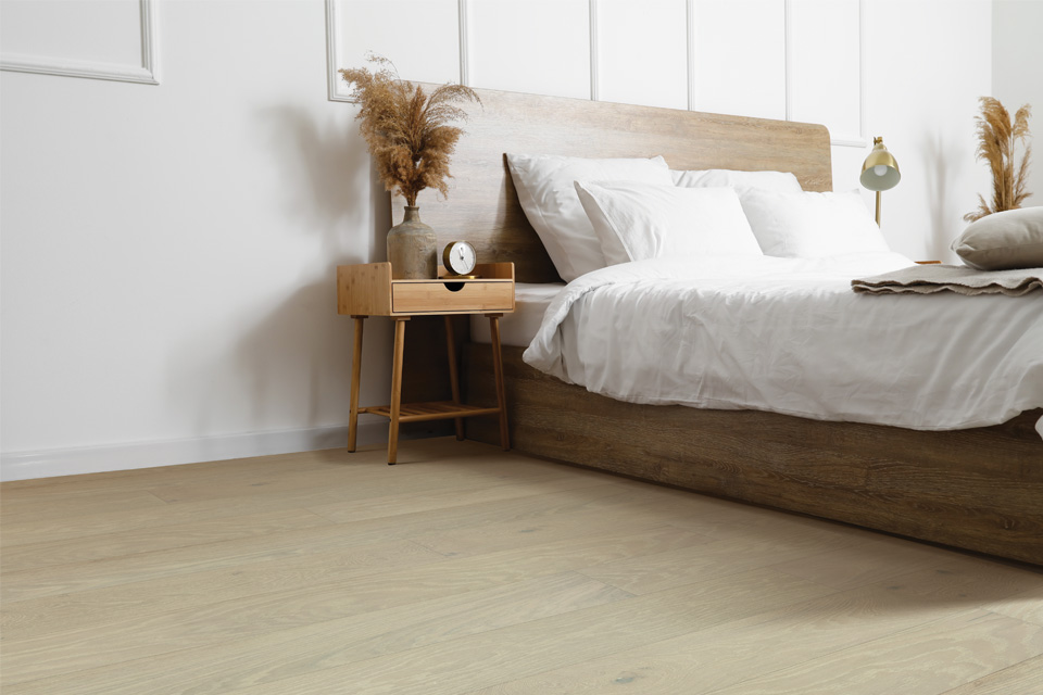 hardwood flooring in bedroom with wooden bed frame and natural decor.